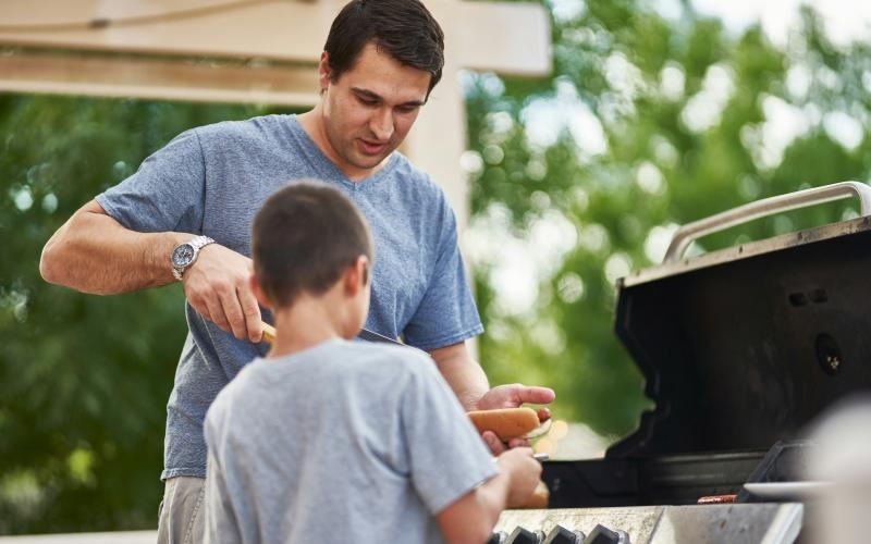 a man and a boy grilling