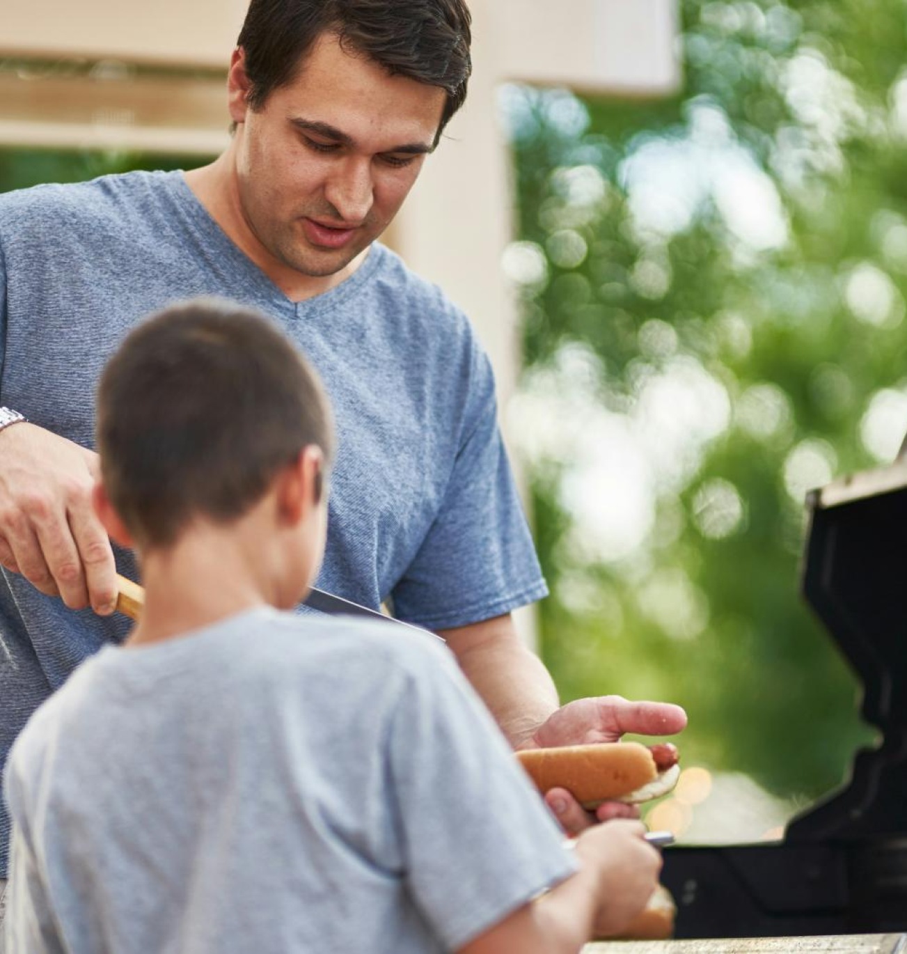 a man and a boy grilling